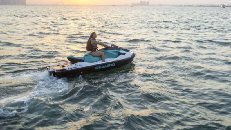 Tourist riding jet ski at sunset during Dhow Boat Doha package