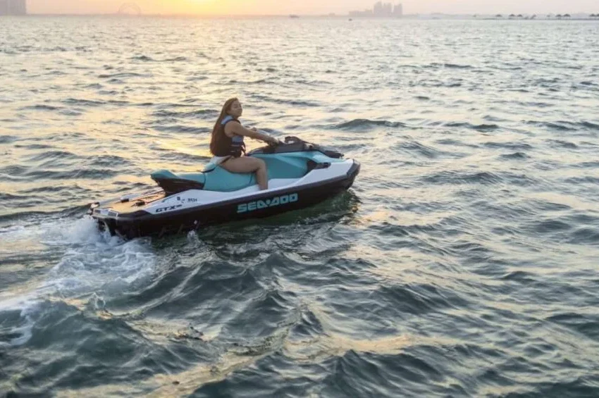 Tourist riding jet ski at sunset during Dhow Boat Doha package