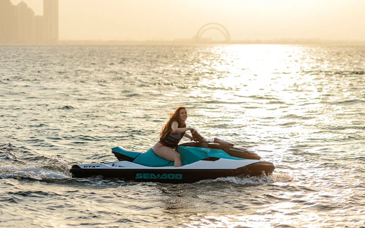 Woman riding jet ski on Doha waters during Dhow Cruise package
