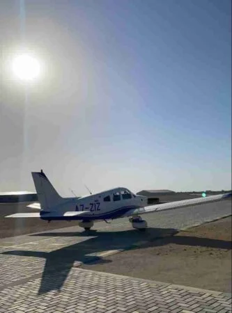 Piper Archer light aircraft parked in Qatar under bright sky