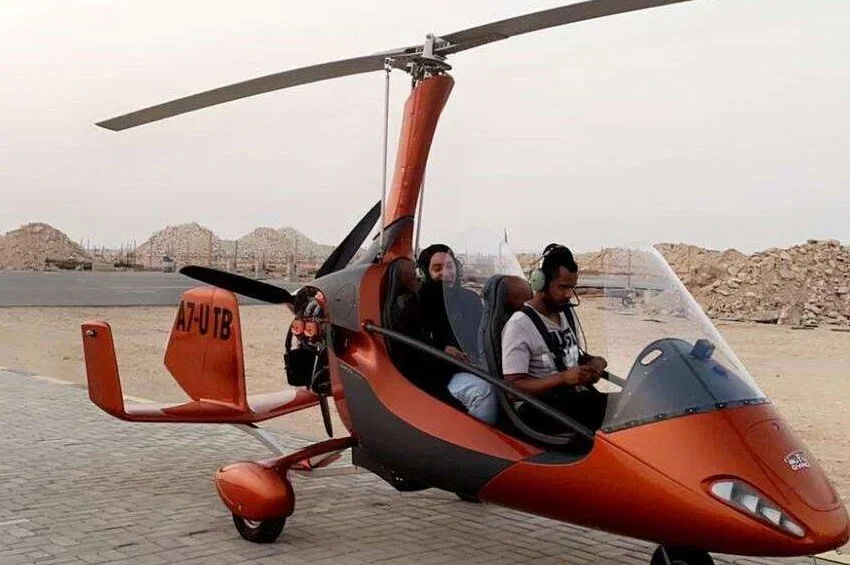 Two passengers ready for gyrocopter tour in Qatar desert