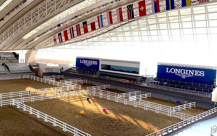 Indoor horse training arena with international flags at Al Shaqab Doha Qatar
