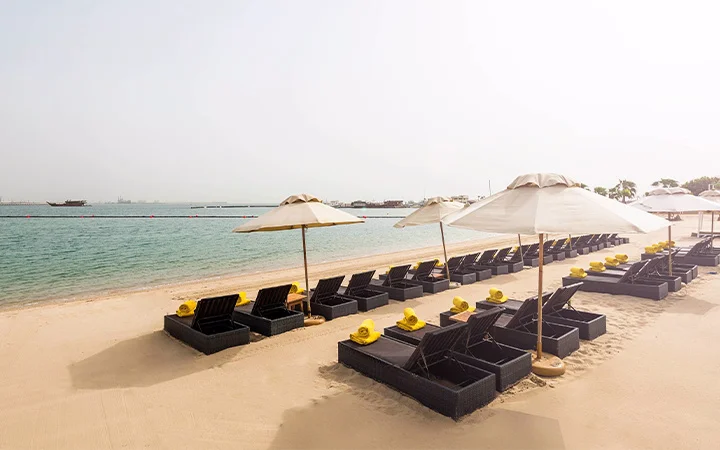 Private beach loungers with umbrellas at Al Sharq Beach Doha Qatar