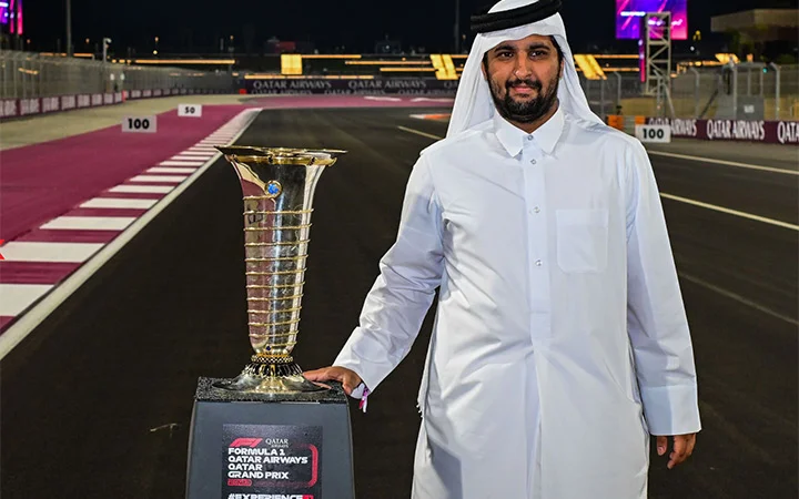Guest posing with Formula 1 trophy at Champions Club Qatar track