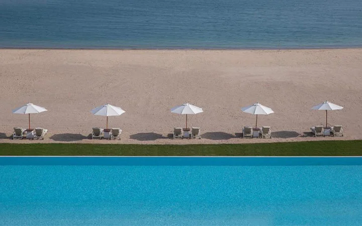 Relax on beachfront loungers at Chedi Katara Beach in Doha Qatar
