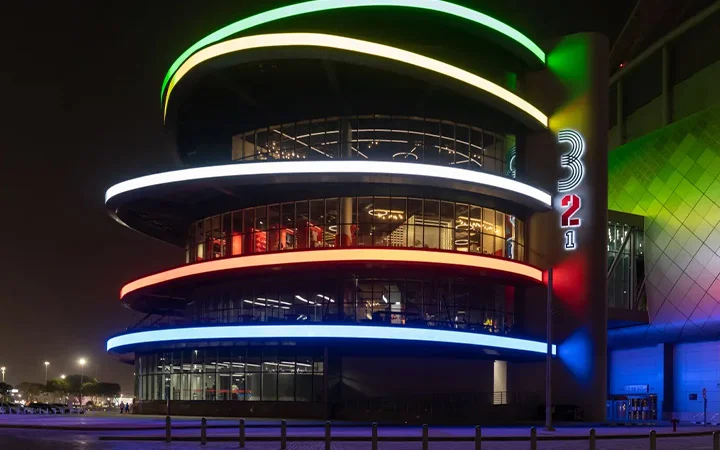 Exterior of 3-2-1 Qatar Olympic and Sports Museum in Doha illuminated with colorful lights