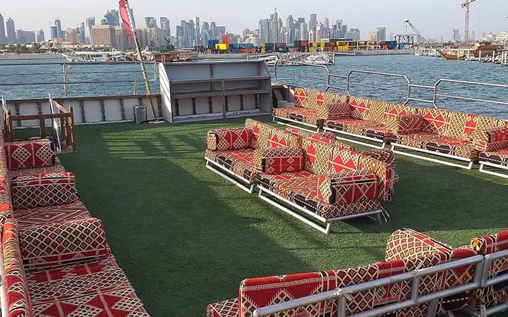 Spacious dhow seating area with sea view during sunset cruise