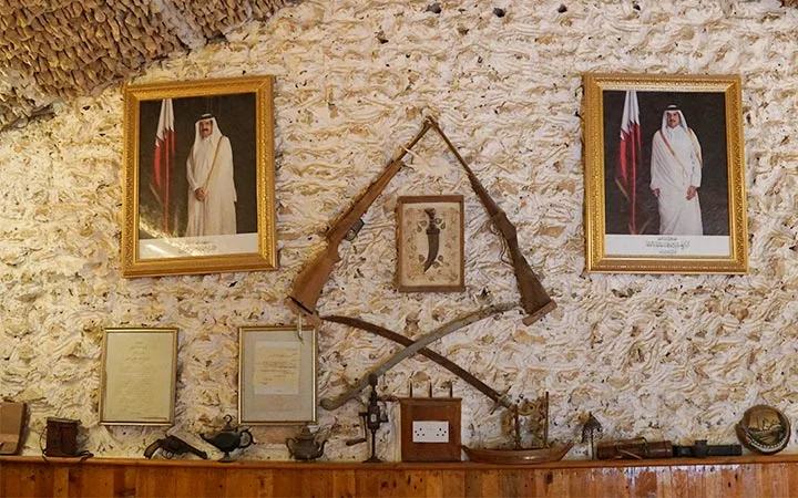 Heritage wall with traditional weapons and portraits at Ain Mohamed Village Qatar