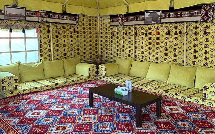 Colorful yellow-decor majlis tent interior at Ain Mohamed Village Qatar