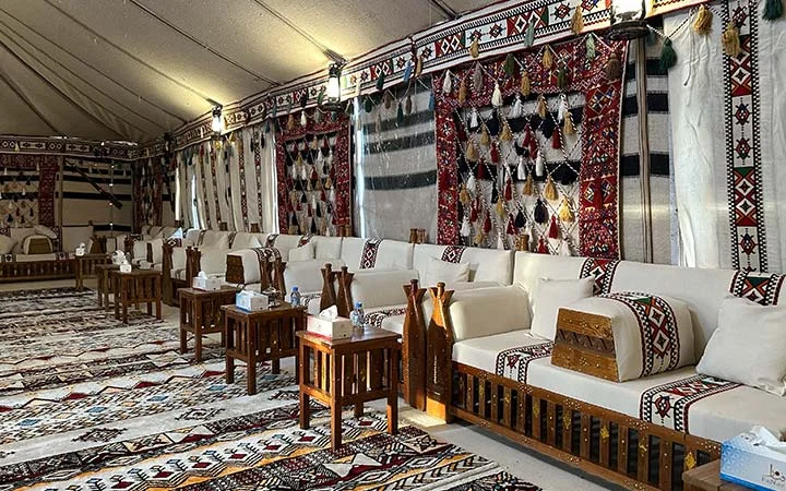 White majlis seating with patterned carpets at Ain Mohamed Village Qatar