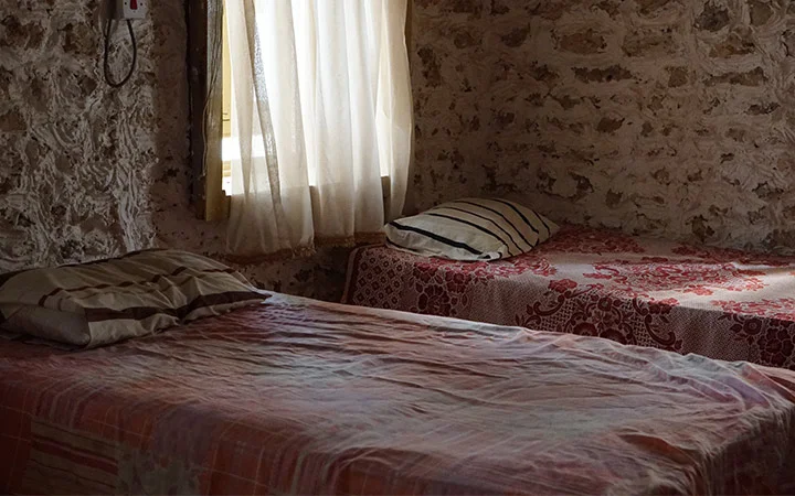 Traditional stone-wall guest room with bed at Ain Mohamed Village Qatar