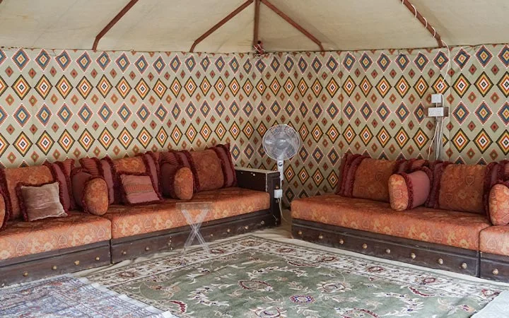 Traditional majlis seating with patterned walls inside Ain Mohamed Village Qatar